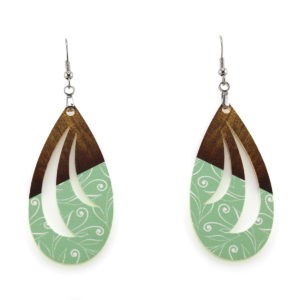 wooden look teardrop earrings melded with white flourishes on a green background