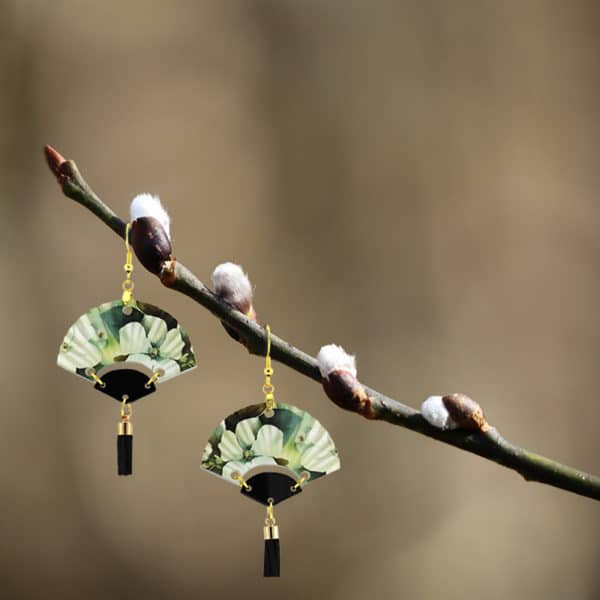 white sakura blossom fan earrings hanging on a pussy willow branch