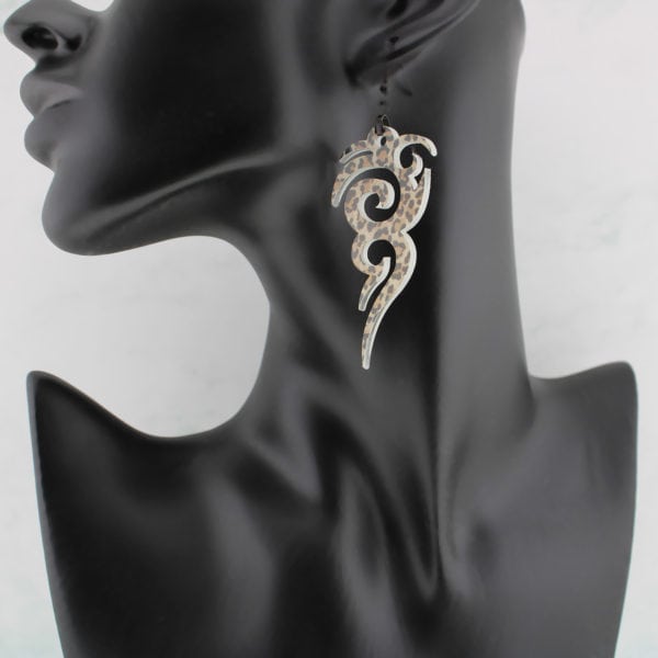 edgy tribal earrings with leopard spots on a black mannequin