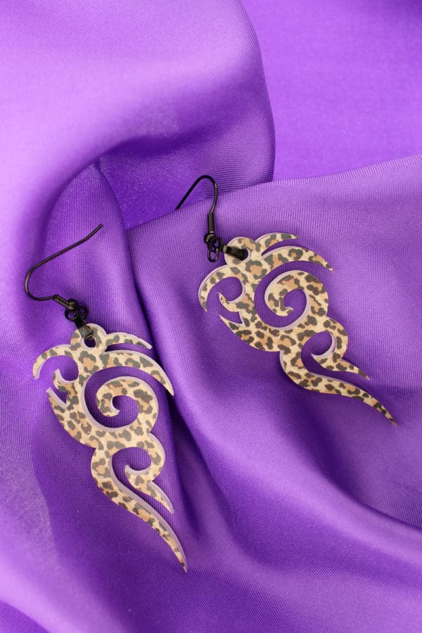 edgy tribal earrings with leopard spots on purple satin